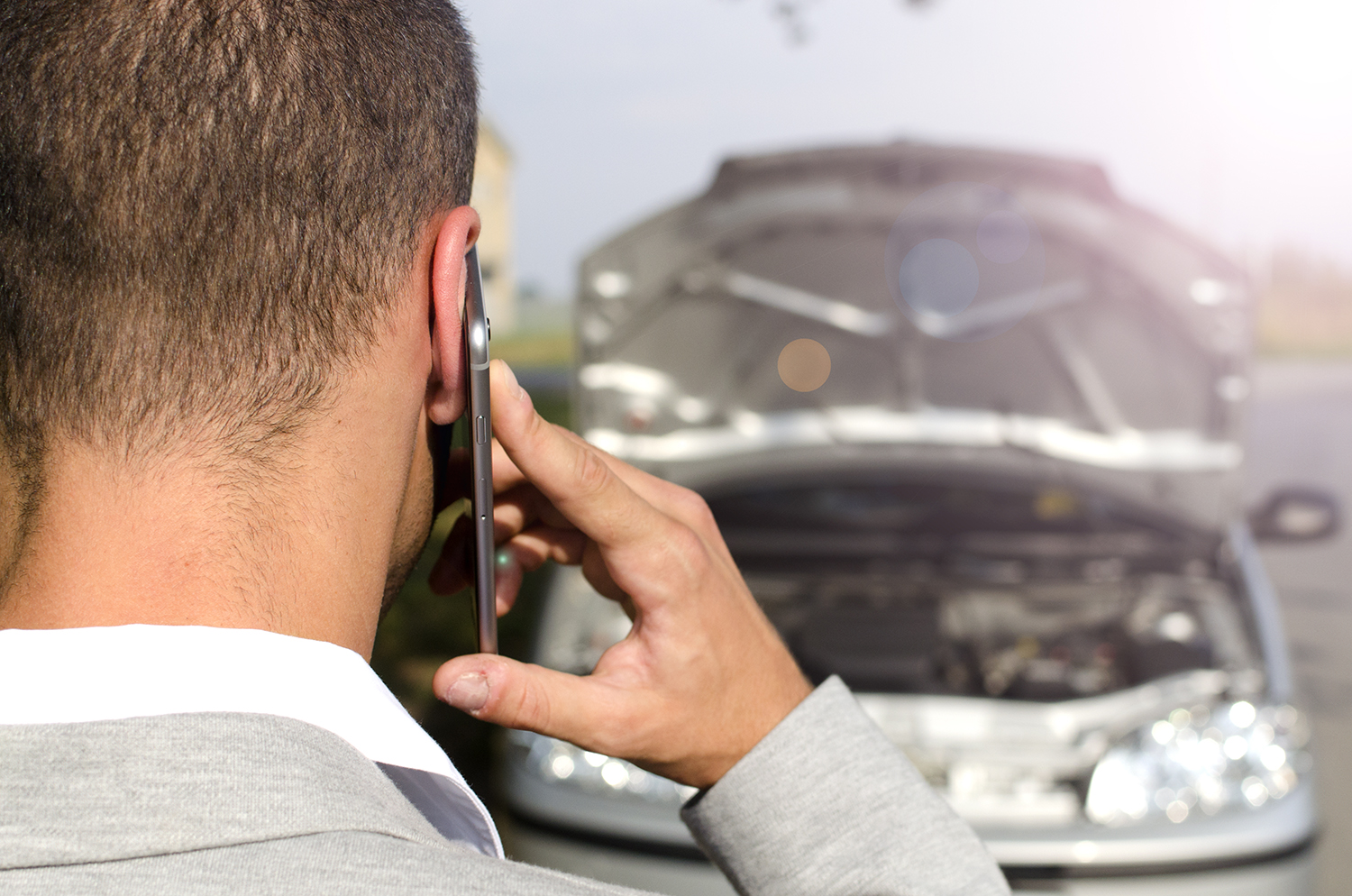Mann telefoniert am Fahrzeug